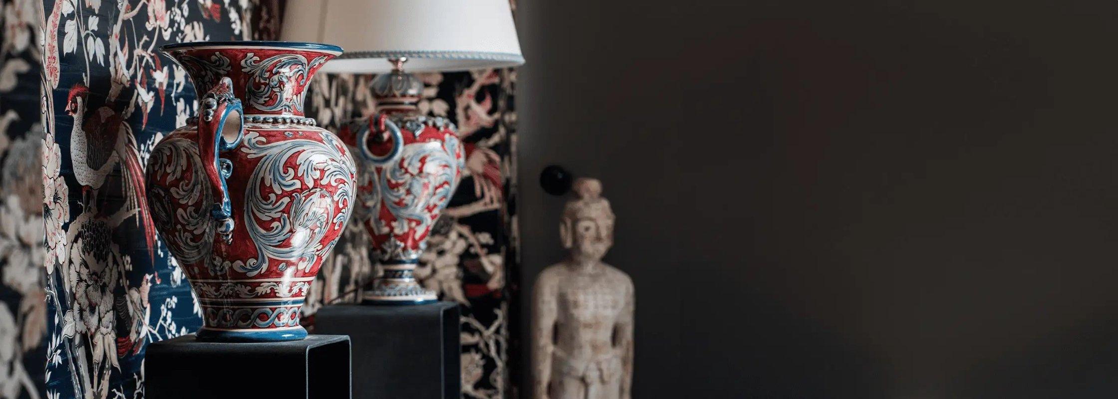 Vasi decorativi ceramiche caltagirone fatti a mano con motivi colorati su sfondo floreale.