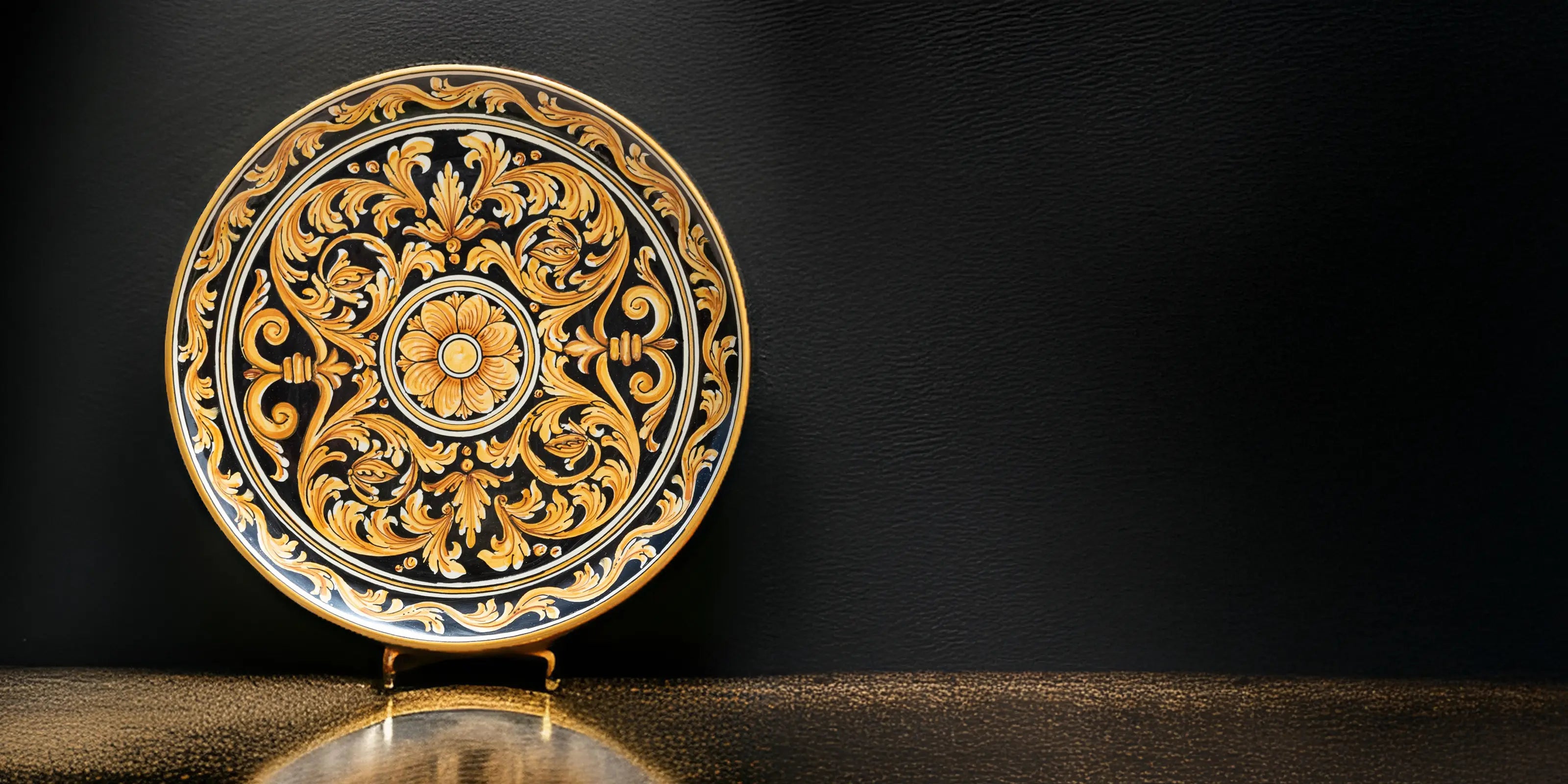 Piatto decorativo ceramiche Caltagirone fatti a mano su sfondo nero, stile artigianale.