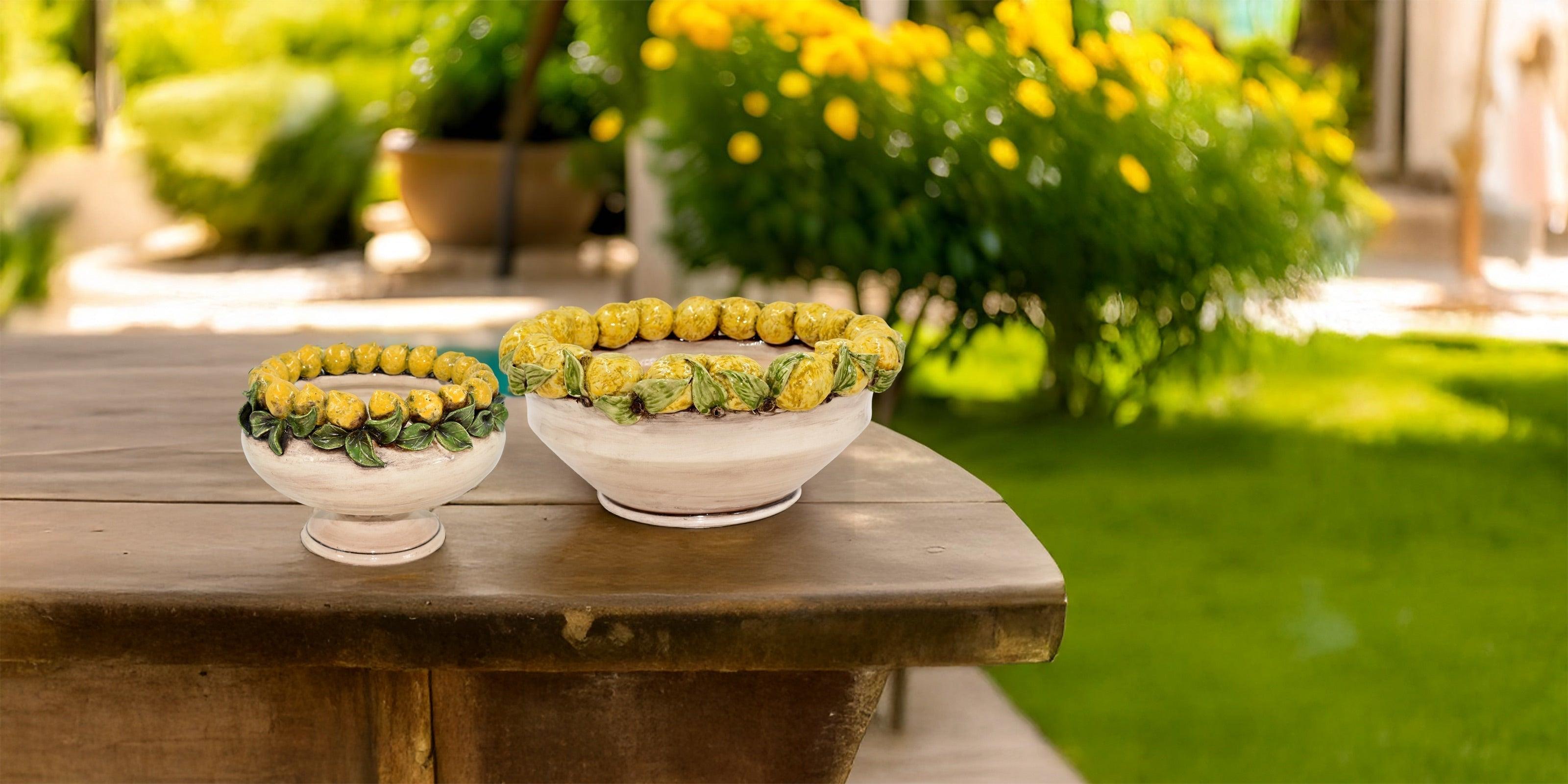 Ciotole ceramiche di Caltagirone Sofia con limoni siciliani, fatti a mano, su tavolo in giardino