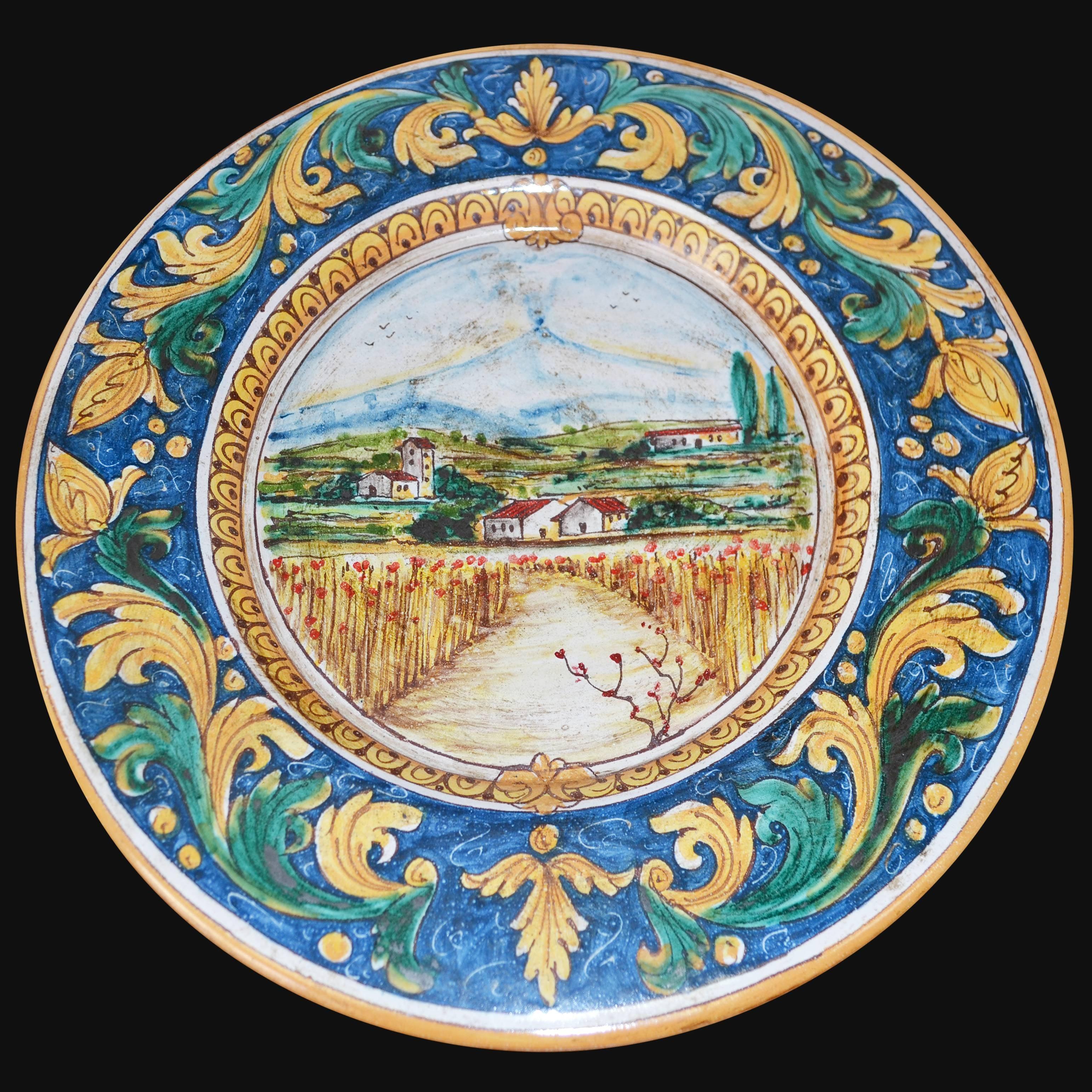 Piatto in ceramica di Caltagirone fatto a mano con paesaggio rurale e decori blu, gialli e verdi