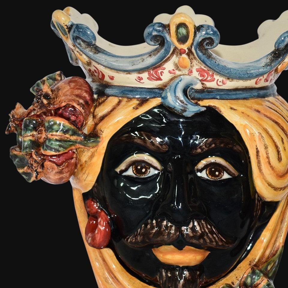 Ceramiche di Caltagirone fatti a mano: maschera reale con corona e dettagli colorati, arte tradizionale siciliana.