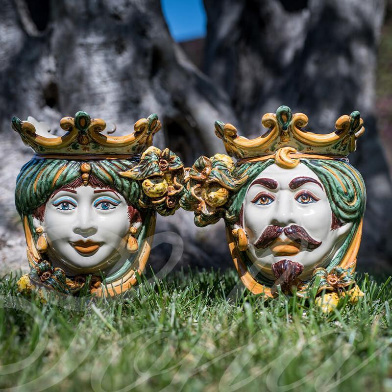 Ceramiche di Caltagirone fatti a mano: volti regali colorati su erba, arte tradizionale siciliana
