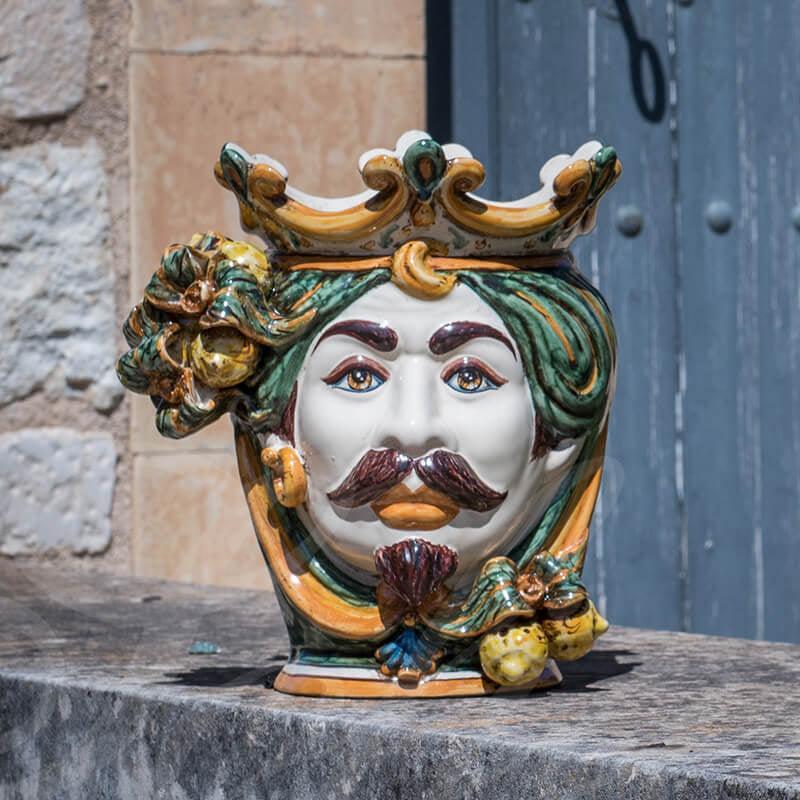 Ceramiche di Caltagirone fatti a mano con volto regale e corona colorata, arte tradizionale siciliana