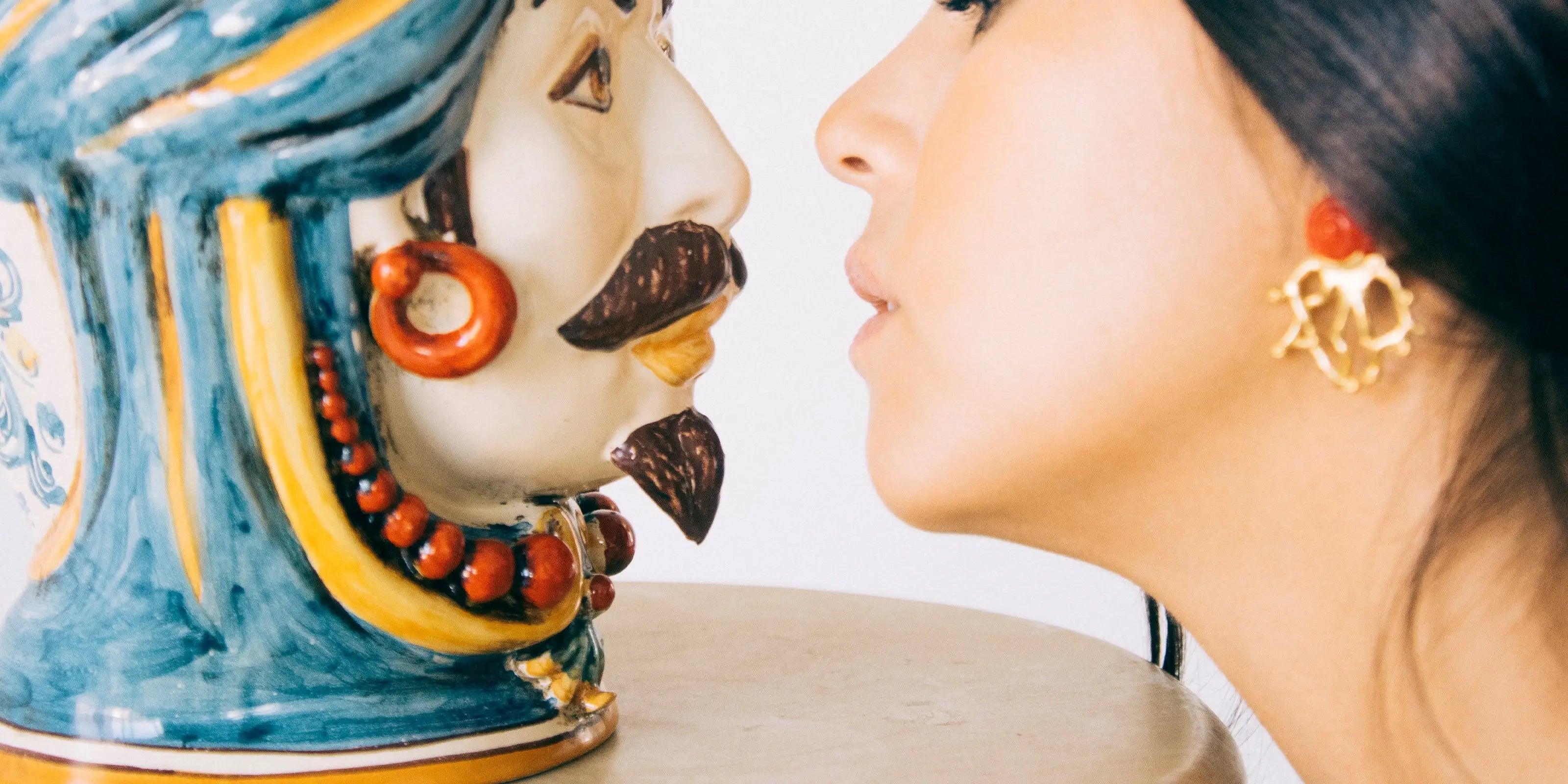 Donna vicina a una testa ceramica di Caltagirone Sofia, ceramiche fatti a mano colorate