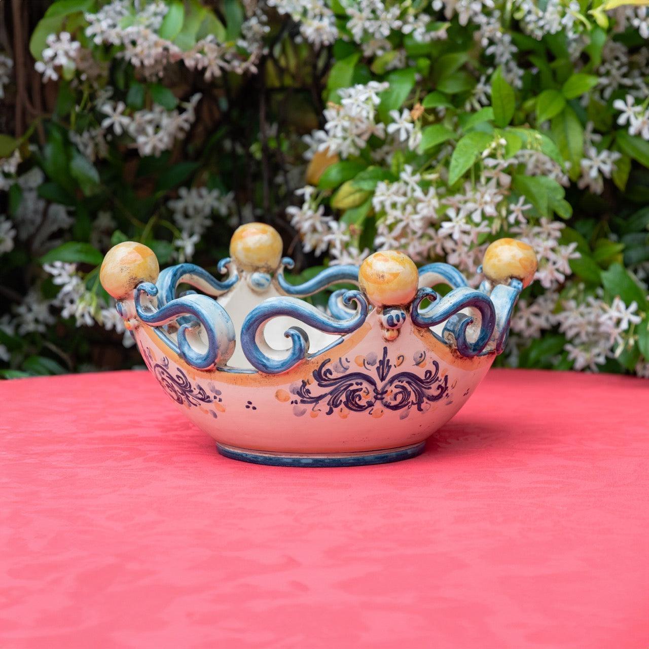 Centrotavola in ceramica Caltagirone fatti a mano blu e arancio su tavolo rosso