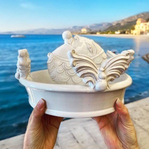 Centrotavola bianco in ceramica artistica di Caltagirone fatti a mano con decorazioni a forma di pesce e ali, vista mare