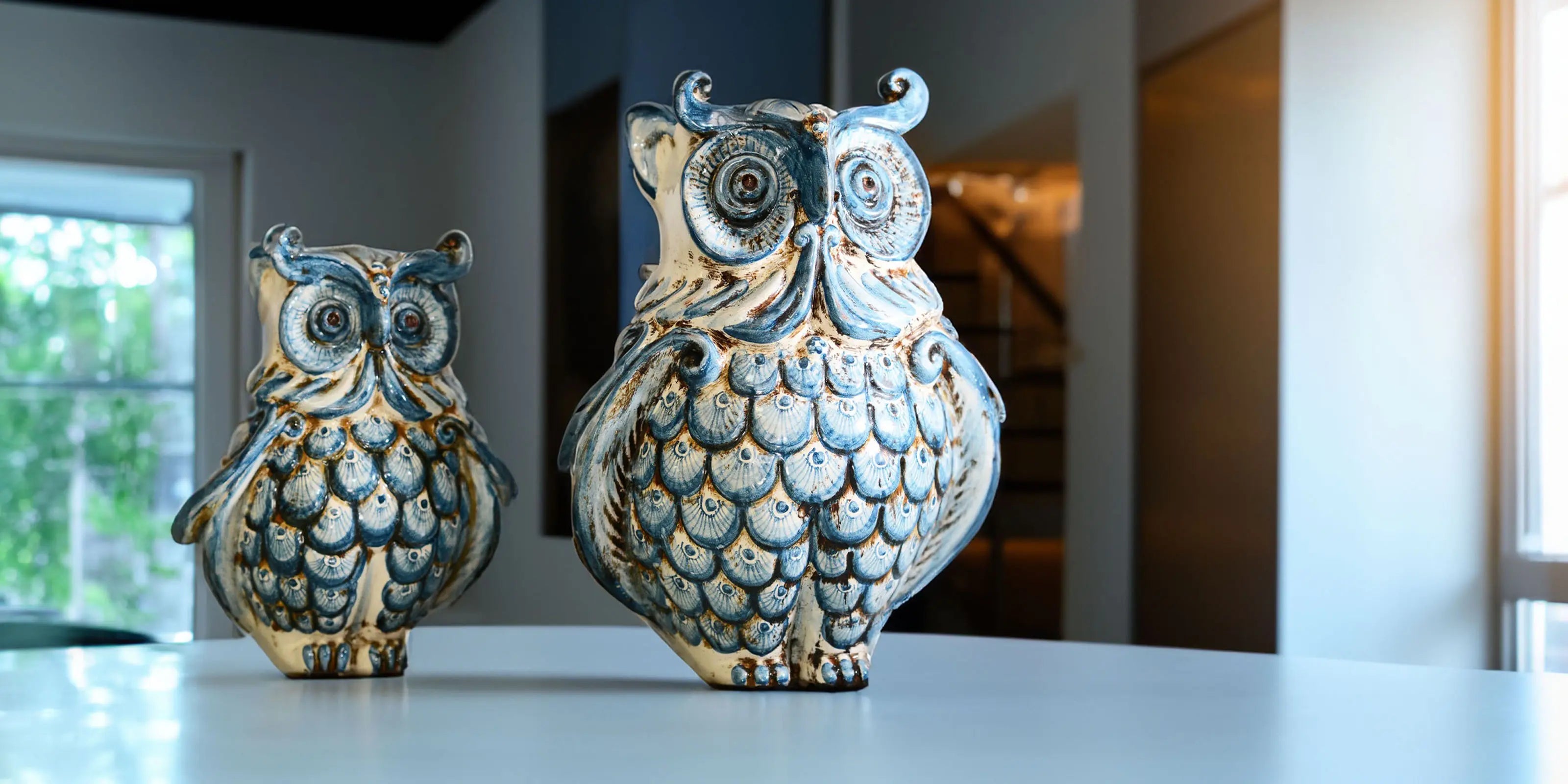 gufi in ceramica caltagirone fatti a mano, decorazione blu e beige, su tavolo