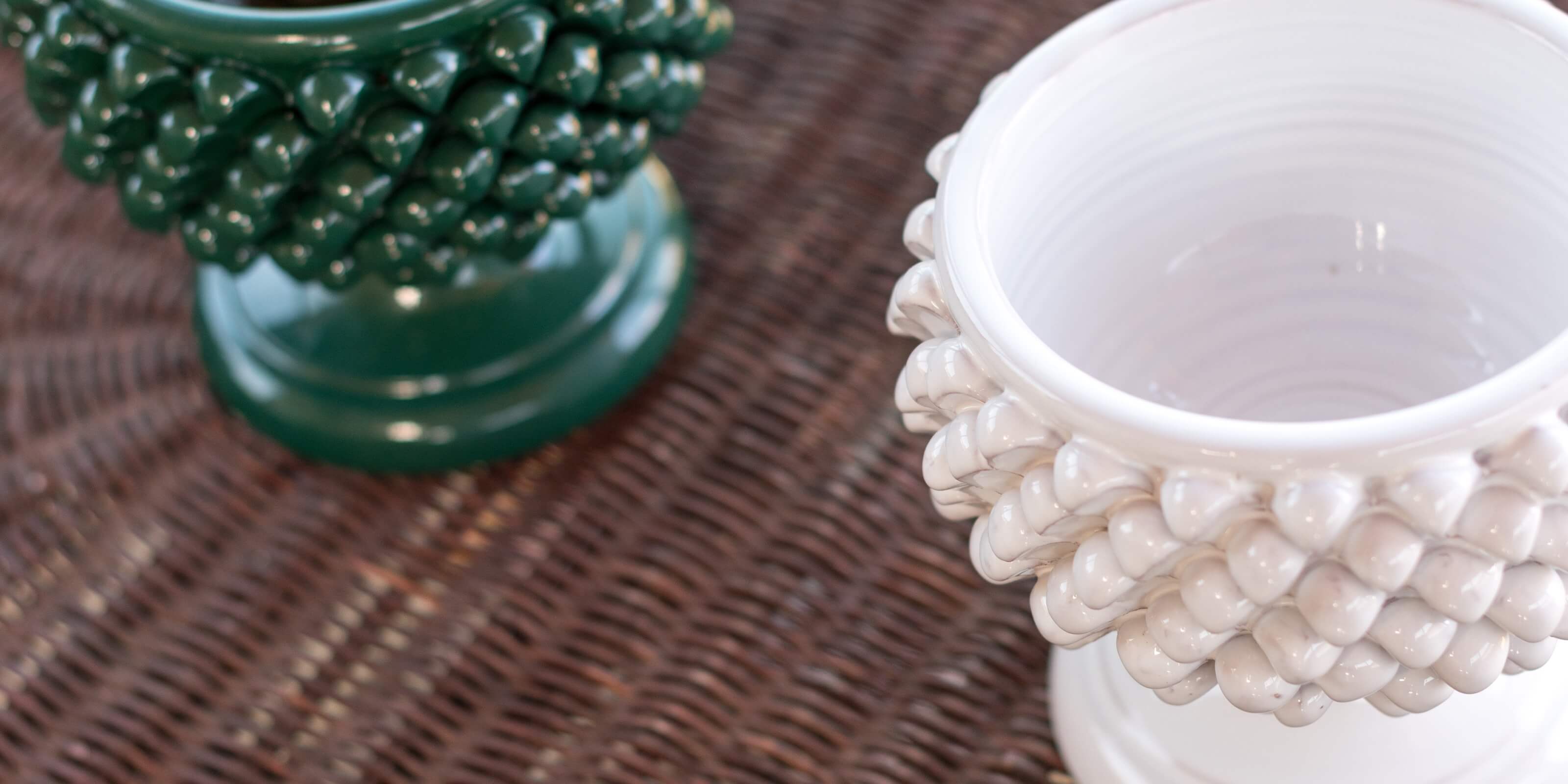 ceramiche Caltagirone fatti a mano, pigne decorative verde e bianca su fondo intrecciato