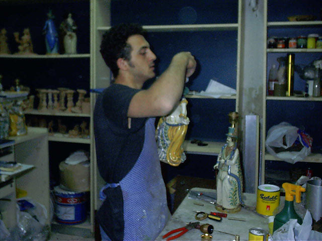 Artigiano che lavora ceramiche caltagirone fatti a mano in laboratorio artigianale.