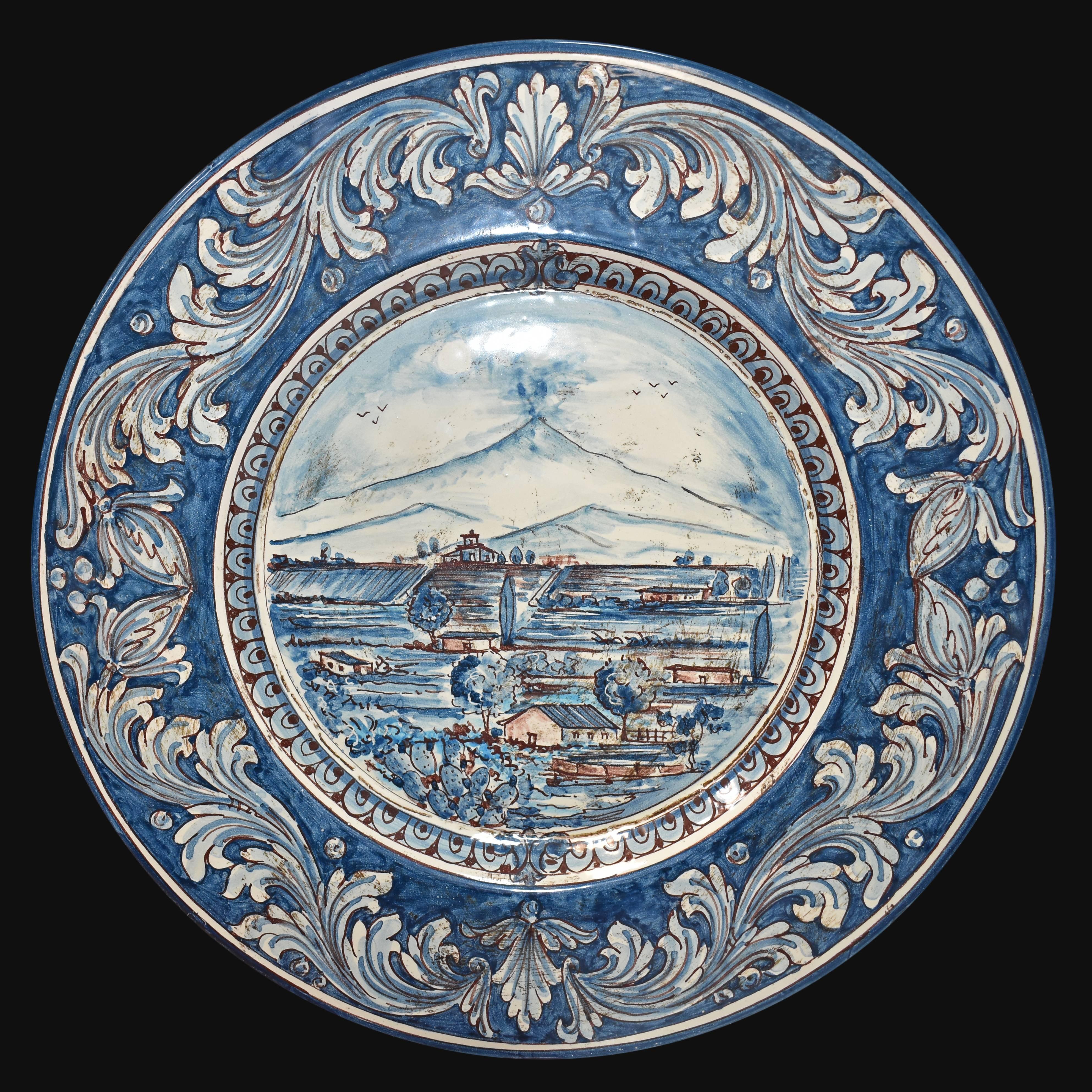Piatto in ceramica di Caltagirone fatto a mano con paesaggio blu e decori floreali