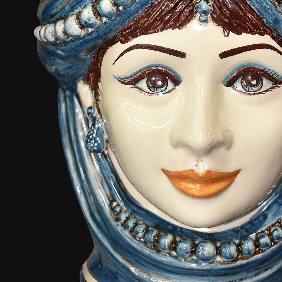 Ceramica di Caltagirone fatta a mano con volto femminile e dettagli blu, arte tradizionale siciliana